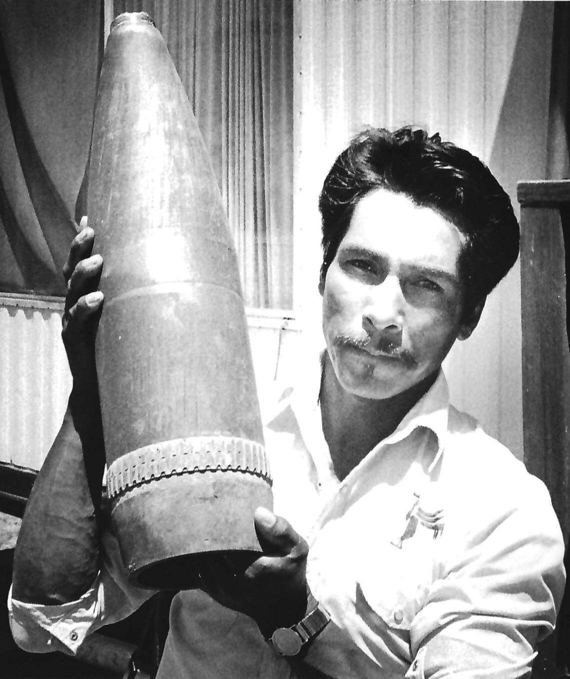 Ranch worker Rafael Aguilar holds a shell from Camp Roberts that landed on a nearby ranch and decorates his doorway. Story published June 28, 1989.