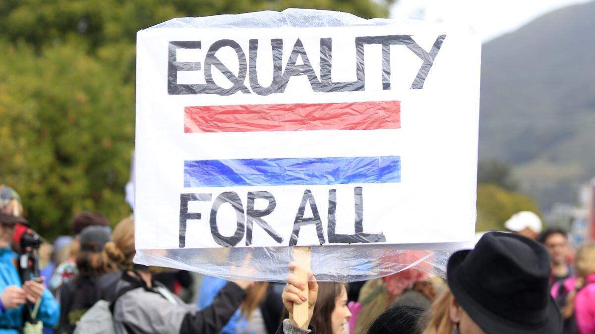 A protester holds a sign at the San Luis Obispo Women's March in January 2017. San Luis Obispo County saw an uptick in hate crime reports in 2017, when the region reported the most incidents since 2013.