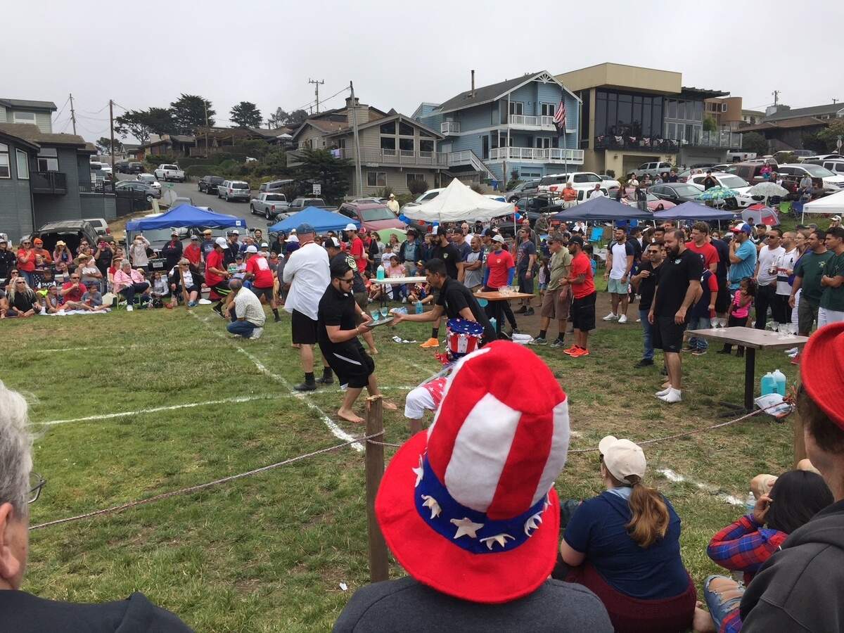 A server dashes across the sod during a waiter-waitress race at one of Cambria’s July 4th celebrations in Shamel Park.