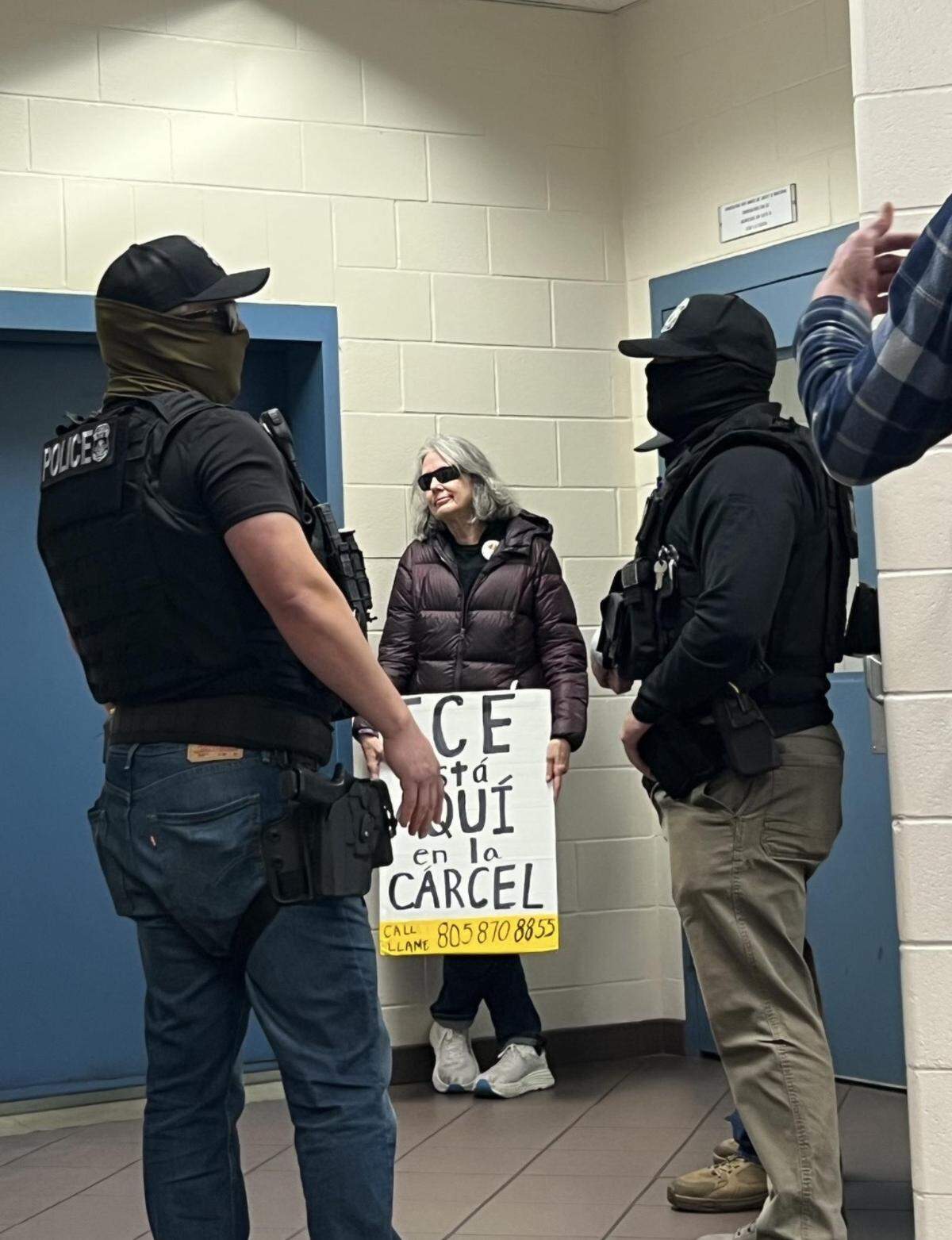 Protester Sue M. held a sign in the jail lobby to warn inmates that ICE agents were waiting there on Dec. 14, 2025.