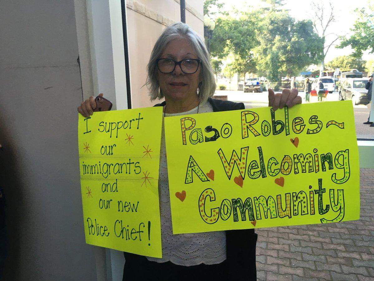 Leslie Moss holds up a sign supporting Paso Robles' immigrant community and Cmdr. Ty Lewis, the city's incoming police chief. Moss joined other residents at a City Council meeting on Tuesday, May 1, 2018, where officials discussed California's "sanctuary state" law.