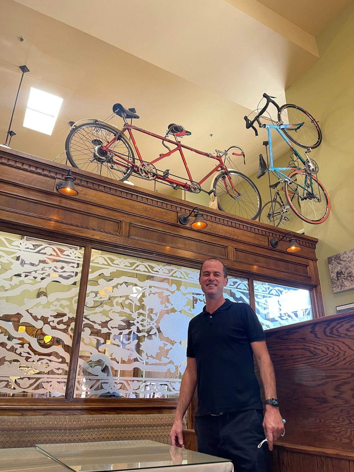 Aaron Linn poses for a picture at Linn’s Restaurant in Cambria near a 1938 Italian multi-geared bicycle built for two.