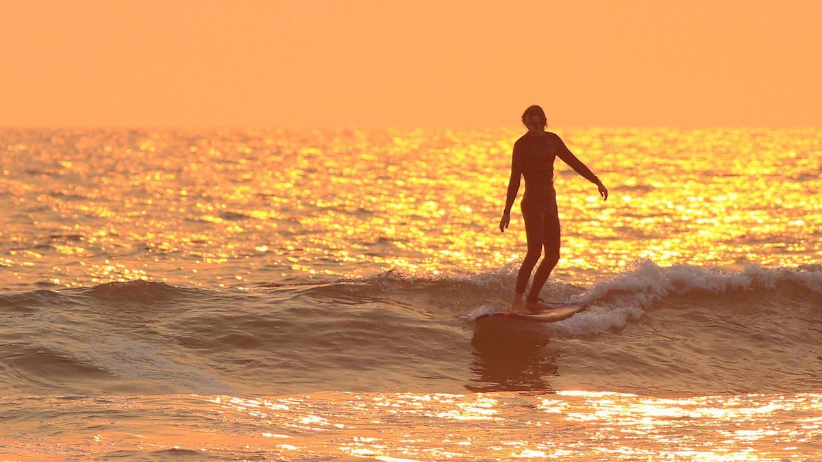 A surfer takes a ride at sunset in Pismo Beach on Tuesday, Aug. 18, 2020. Sunsets have had spectacular color but air quality on the Central Coast is poor due to smoke from several fires burning in Monterey County.
