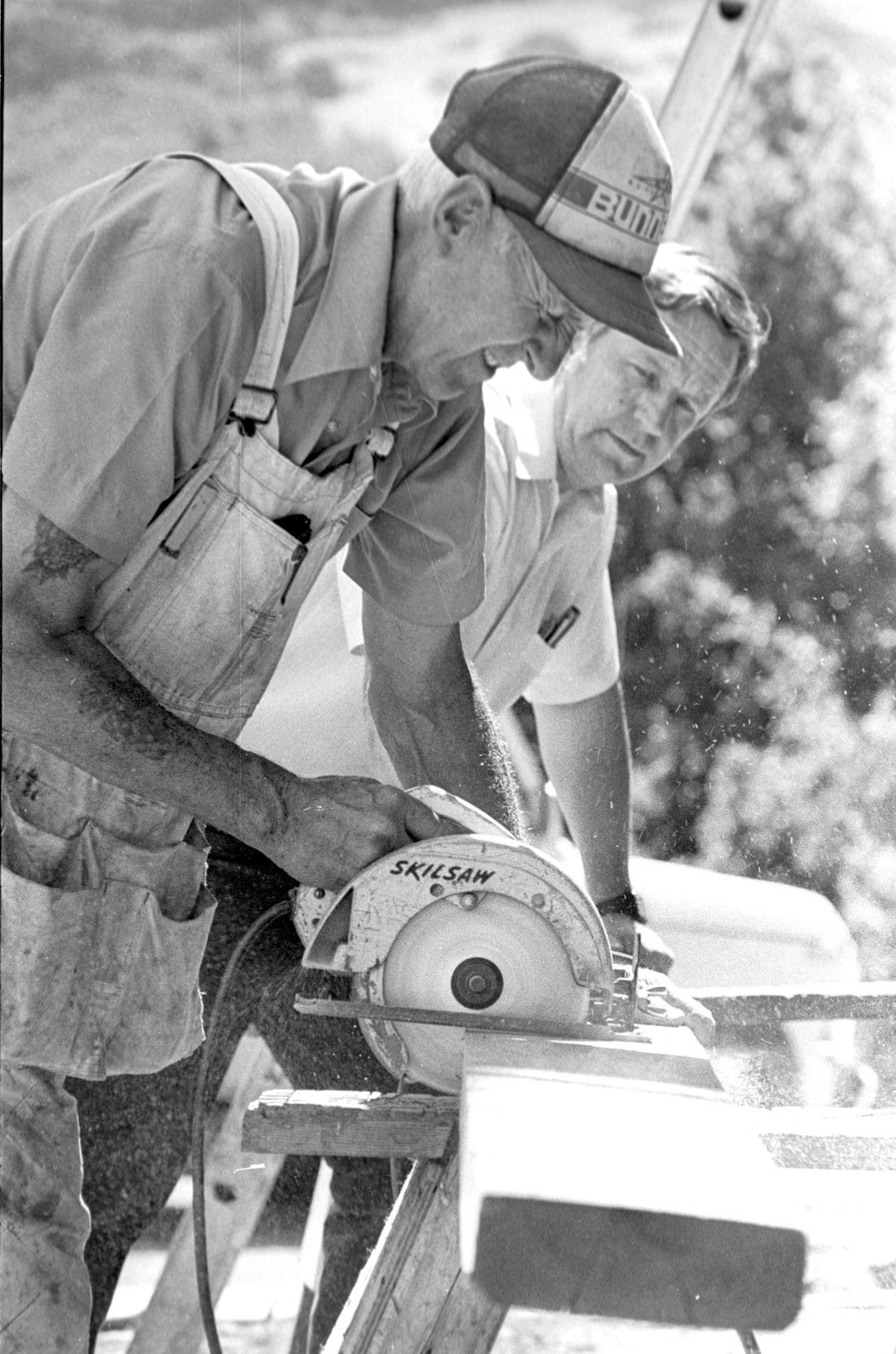 Carl Nilsen, left, is assisted by construction company owner Ray Bunnell as restoration efforts were underway on the almost century-old dairy barn Aug. 17, 1982. The Mail Pouch Barn on Highway 1 at the base of Bishop Peak carried a chewing tobacco advertisement on the roof for many years. It was a popular subject for artists but when the roof deteriorated it was replaced and not repainted and the advertising campaign ended a few years later.