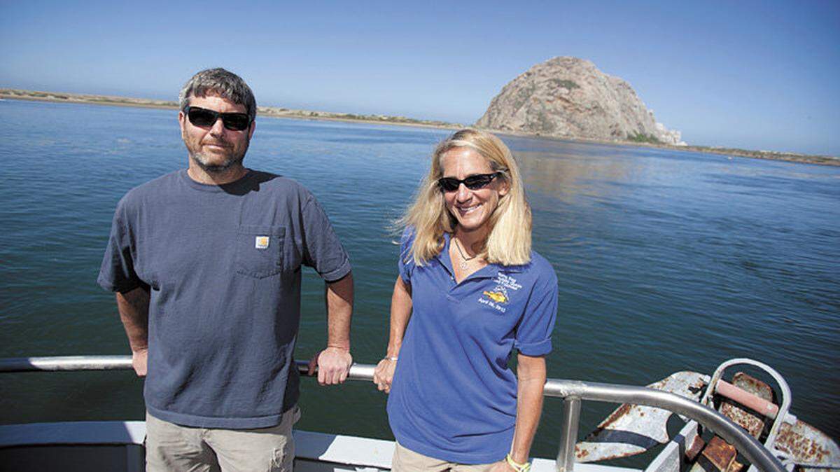 Rob Seitz, a commercial fisherman, and Andrea Lueker, executive director of the Morro Bay Community Quota Fund, stand on Seitz’s trawler docked in Morro Bay Harbor on Sunday. The Morro Bay Community Quota Fund has acquired the city’s fishing quota and permits, one of which Seitz leases, from The Nature Conservancy.