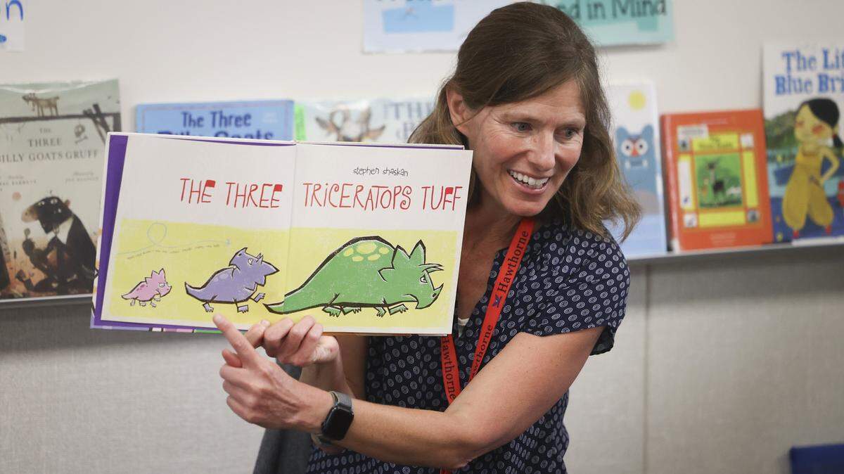 Teacher at Hawthorne Elementary School, Fiona Lloyd-Moffett reads a variation on the previous day's story to her TK students about three billy goats gruff, now in a dinosaur version on Sept. 18, 2025. It is part of a series of stories featuring the number 3 and a chance for student to compare and contrast books.
