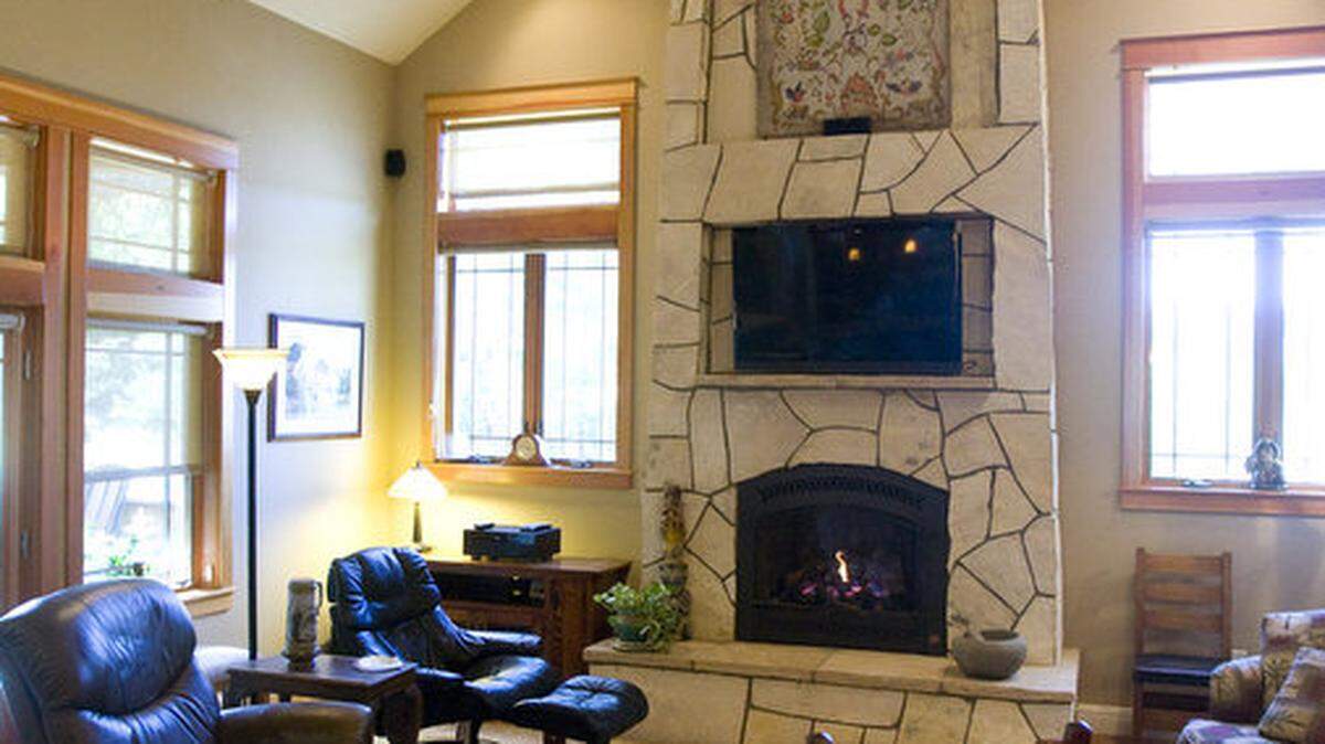 The living room has Craftsman features like a rock fireplace and wood trim, but contemporary high ceilings.