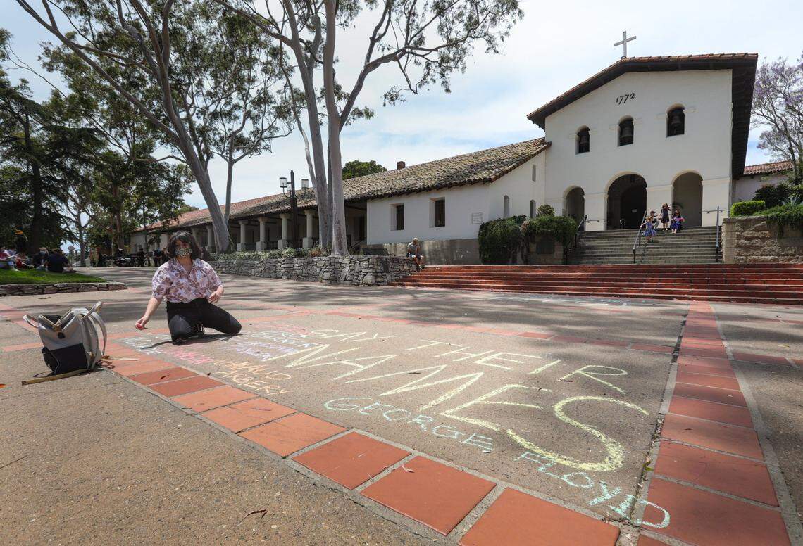 Isabella Nino de Rivera writes “Say their names” in chalk at Mission San Luis Obispo, memorializing recent deaths of Black individuals during police actions.