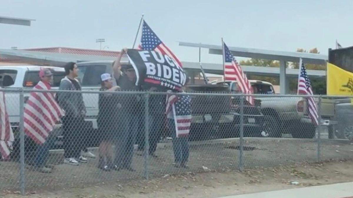 Students in Paso Robles High School’s Conservative Club hold flags on campus in honor of U.S. veterans. One flag said “F--- Biden,” which sparked outrage in some community members for the use of profanity on campus.