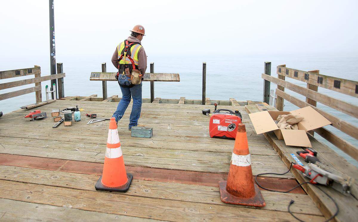 Hank Linder of Hartzell Construction works to repair a portion of the railing on the damaged Cayucos Pier, on Oct. 31, 2025.