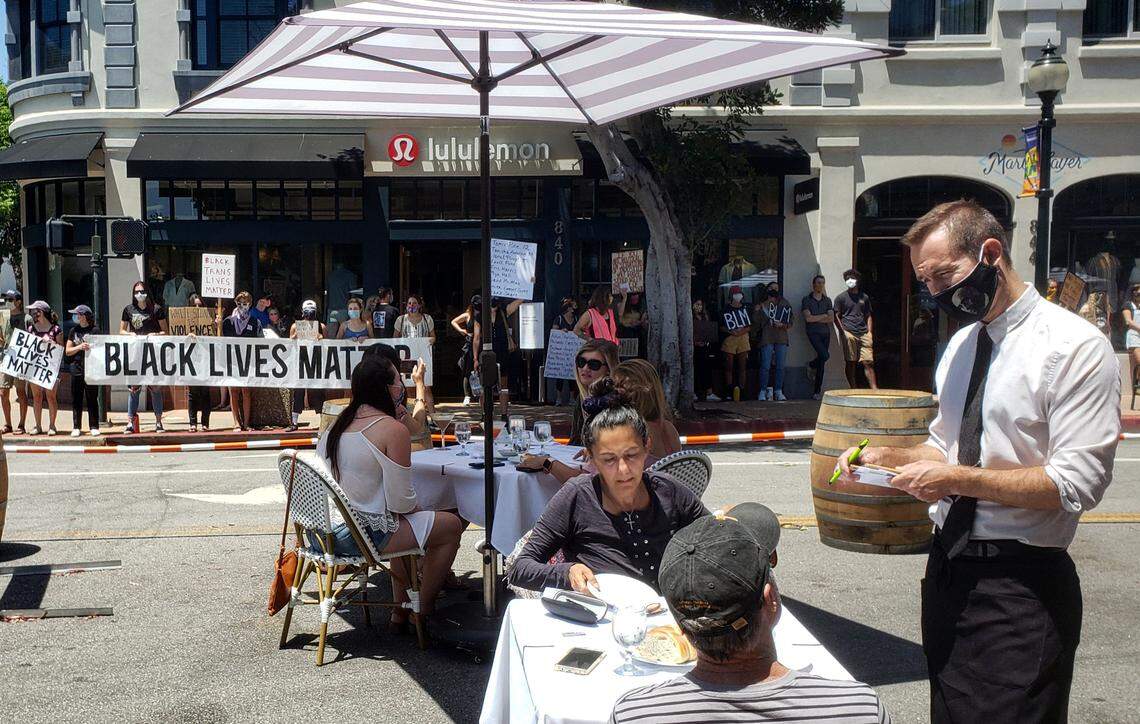 Protesters lined up along businesses surrounding Giuseppe’s and Finney’s outdoor dining parklets during the silent protest on July 25. Protesters are remaining quiet and stayed out of the doorways of businesses.