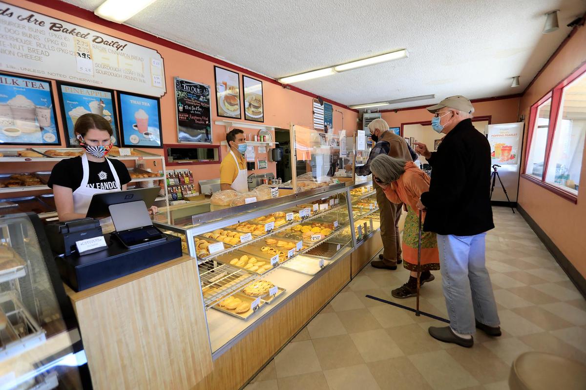Cashier Kimberly Gordon works the register and Dante Garcia helps customers at Carlock’s Bakery in Los Osos.