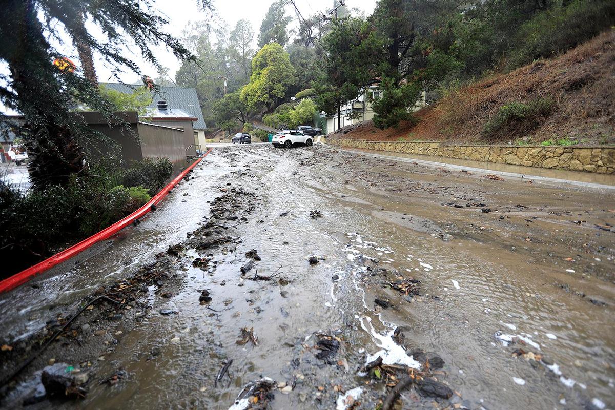 Water and mud flow down Kent Street behind the Shell Station in Cambria. A strong storm hit the North Coast area with heavy rain and high winds on Wednesday, Jan. 27, 2021.