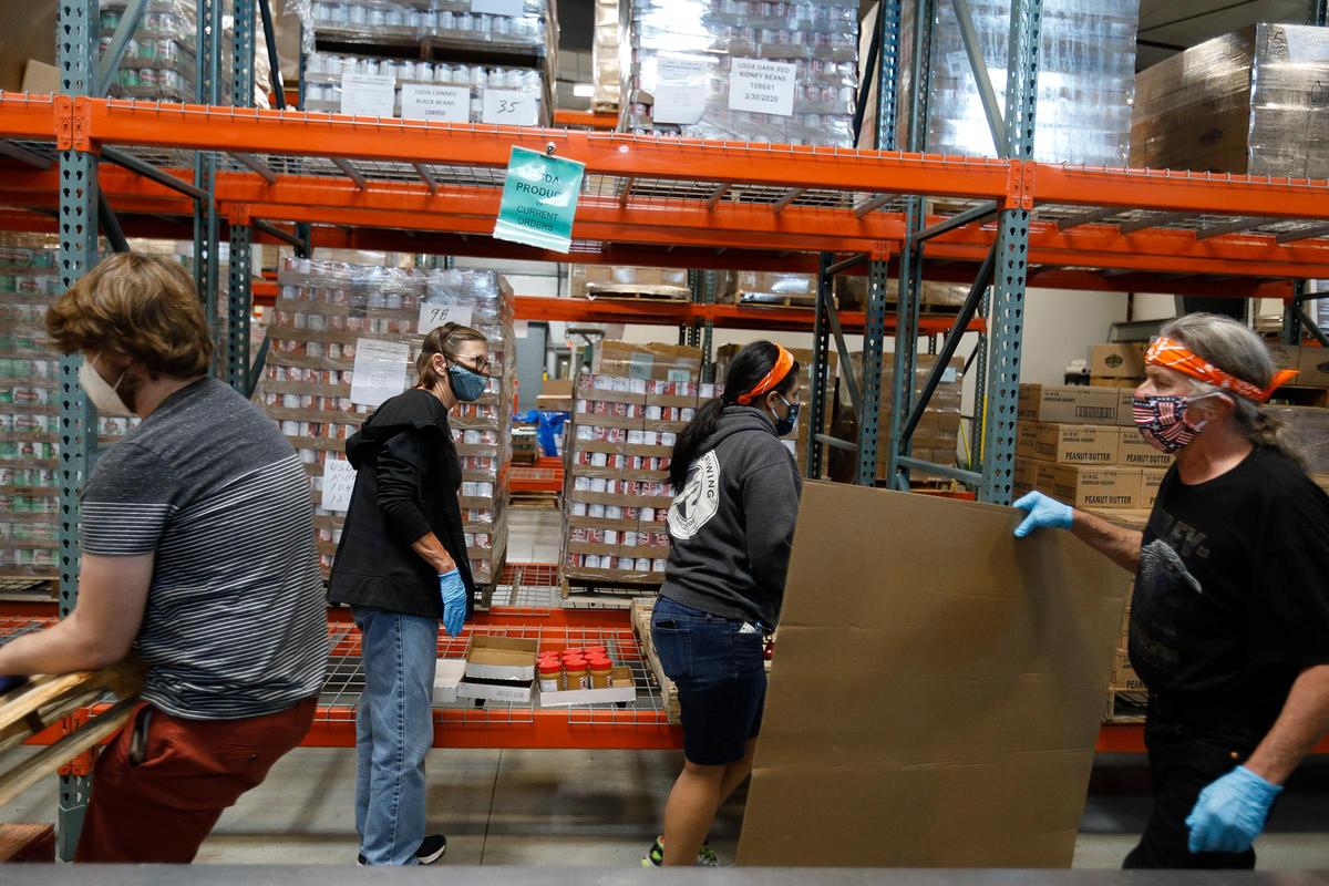 Workers inside the SLO Food Bank warehouse work on hundreds of boxes of food. SLO Food Bank CEO Garret Olson says demand for the San Luis Obispo County food bank has tripled since the start of the coronavirus pandemic.