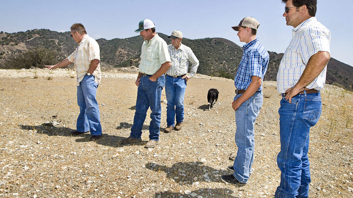 Dero Parker, left, points out where on an existing pad hisexploratory oil and gas well would go to Joe Doud, right, Bryce, Charlie and John Porter.