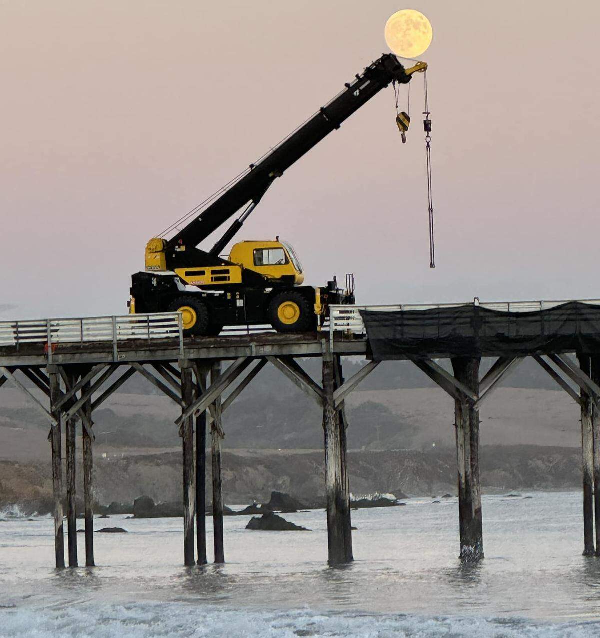 Crews started work Monday, Sept. 16, 2024, to repair the damaged, aging San Simeon Pier, removing some curb rails and other impediments to getting equipment in place. Cambria photographer Debby Boutros captured this moonrise picture that evening. Weather and waves pemitting, it’s anticipated that repairs will take eight months to complete