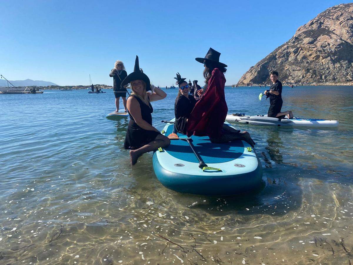Natalie Penney, left, and her friend get ready to embark into the water on Sunday, Oct. 29, 2023, for the 10th annual Morro Bay Witches and Warlocks Paddle.