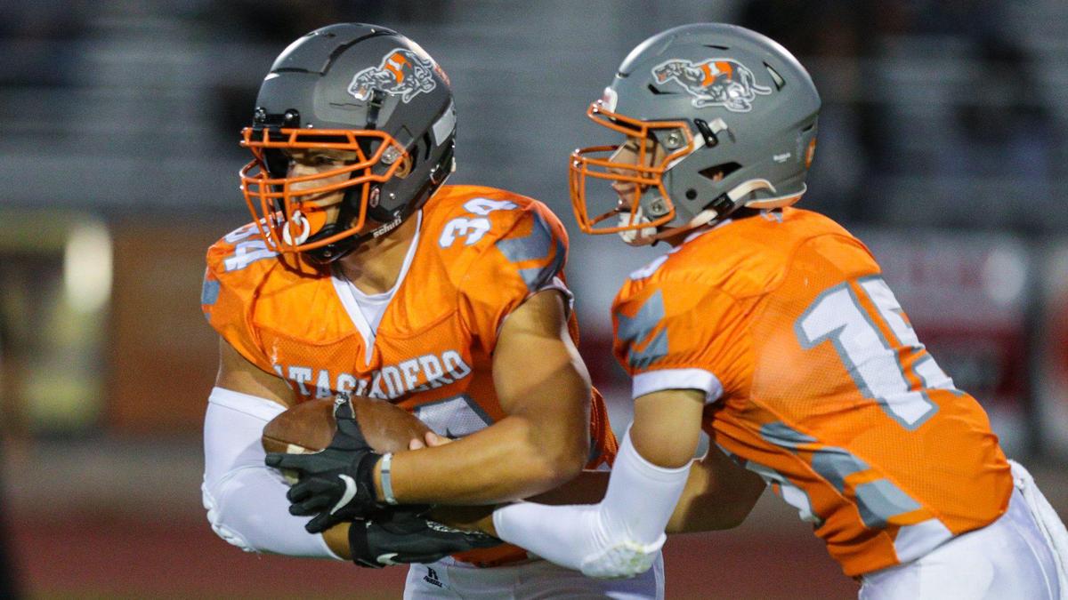 Trey Cooks is The Tribune’s 2022 SLO County high school football player of the year. Here, Cooks gets a handoff from his brother, Kane Cooks. Atascadero won in a football game with San Luis Obispo 28-24 Sep., 23, 2022. The Greyhounds went on to win the CIF Divison 6-A state title.