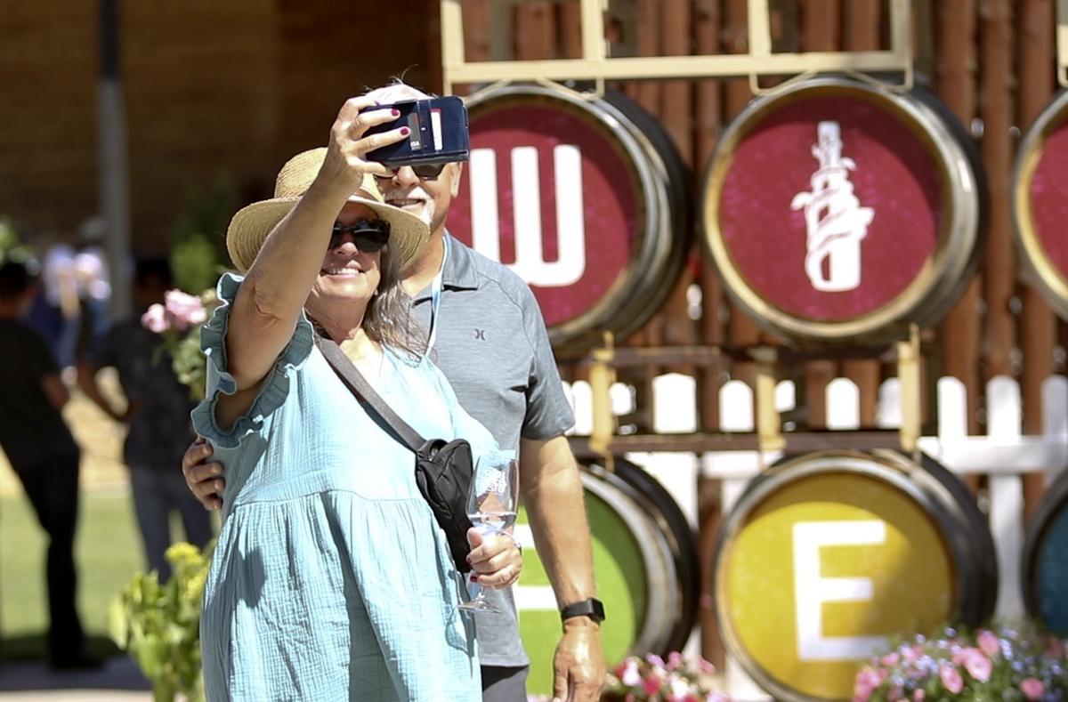 Robin and Kevin Mulvehill of Simi Valley enjoy the Paso Wine Fest on Saturday, May 20, 2023, by taking a selfie in front the wine barrels at the Paso Robles Event Center.