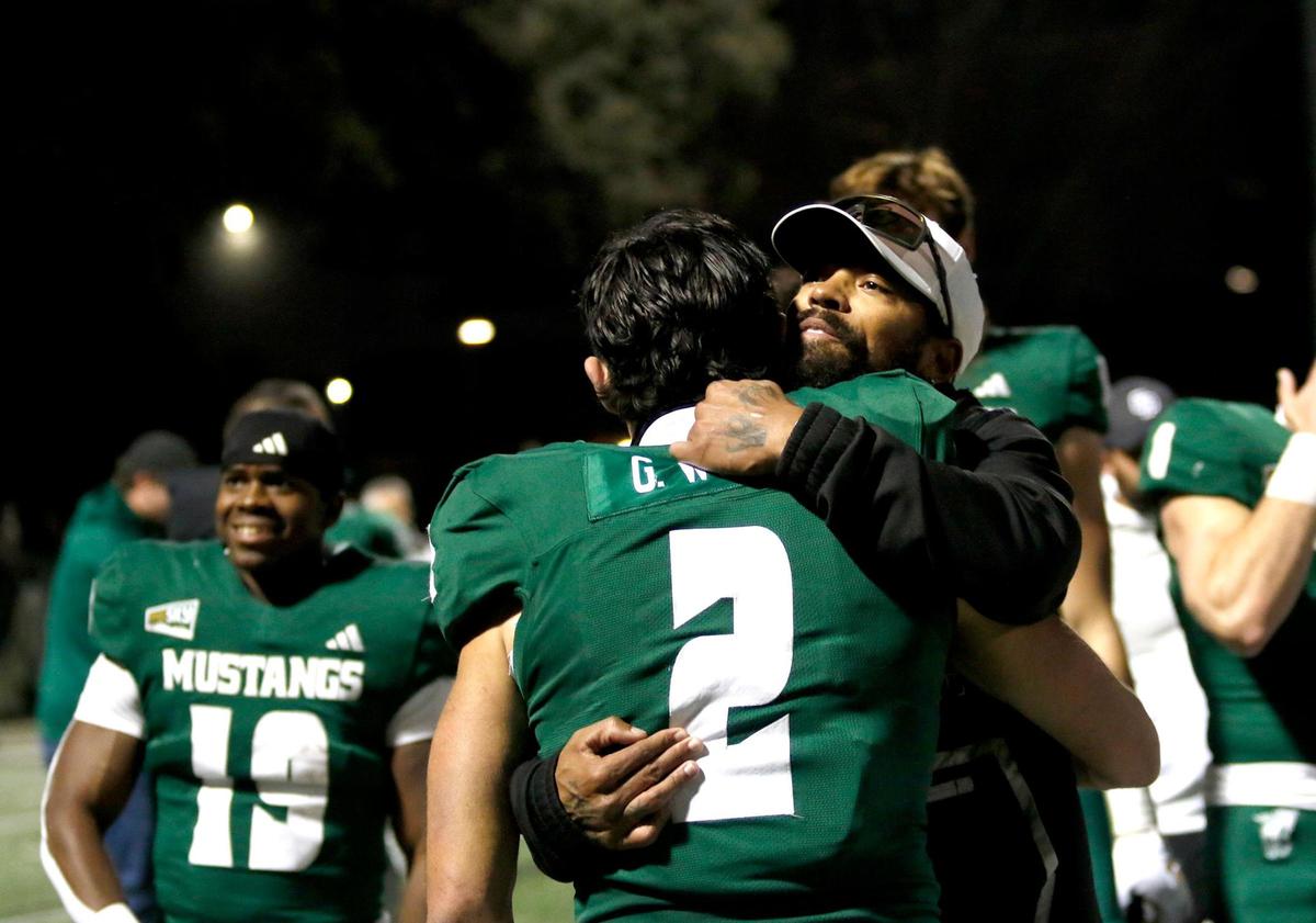 Cal Poly wide receiver Giancarlo Woods gets a hug after the Mustangs’ win. Cal Poly beat Sacramento State 26-23 in a college football game at Mustang Memorial Field on Nov. 16, 2024.