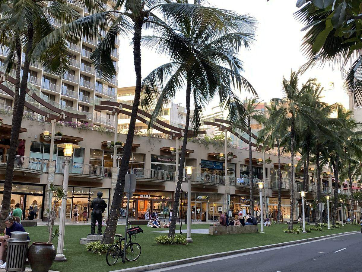 Activities along Wakiki Beach Walk in Honolulu, Hawaii, include shops and eateries.