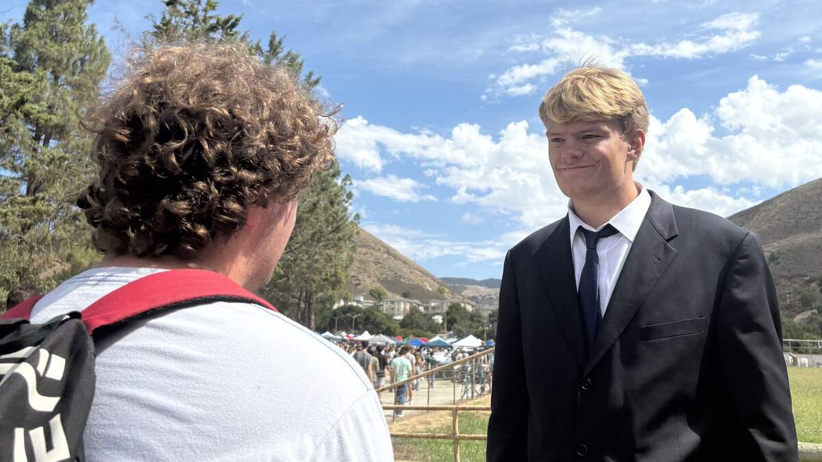 Ryan Rundle, president of the Turning Point USA club at Cal Poly, speaks with a visitor during the Week of Welcome club fair on Sept. 17, 2025. Turning Point USA was founded by Charlie Kirk, a conservative activist who was killed at Utah Valley University.