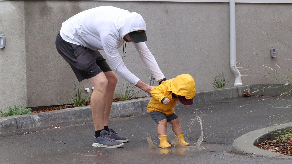 Bryan New helps son Bennett, 2, learn the joy of puddle splashing. First rainfall of the season fell in San Luis Obispo County Sept. 19, 2022.