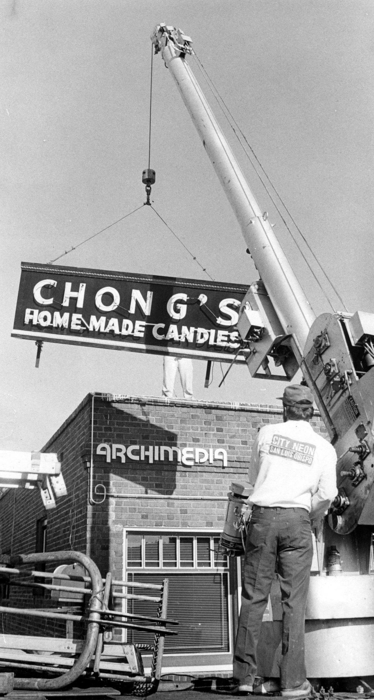 The sign that advertised Chong’s candy store for 28 years was lowered Tuesday by crane operator Dewaine Moerman. The sign will be inside Archimedia which occupied the building Feb. 7 1979 at Palm and Chorro Streets, San Luis Obispo.