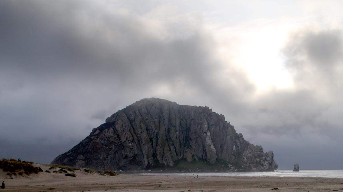 Heavy rain clouds blow in over the Rock before sunset at Morro Bay on Dec. 8, 2021.