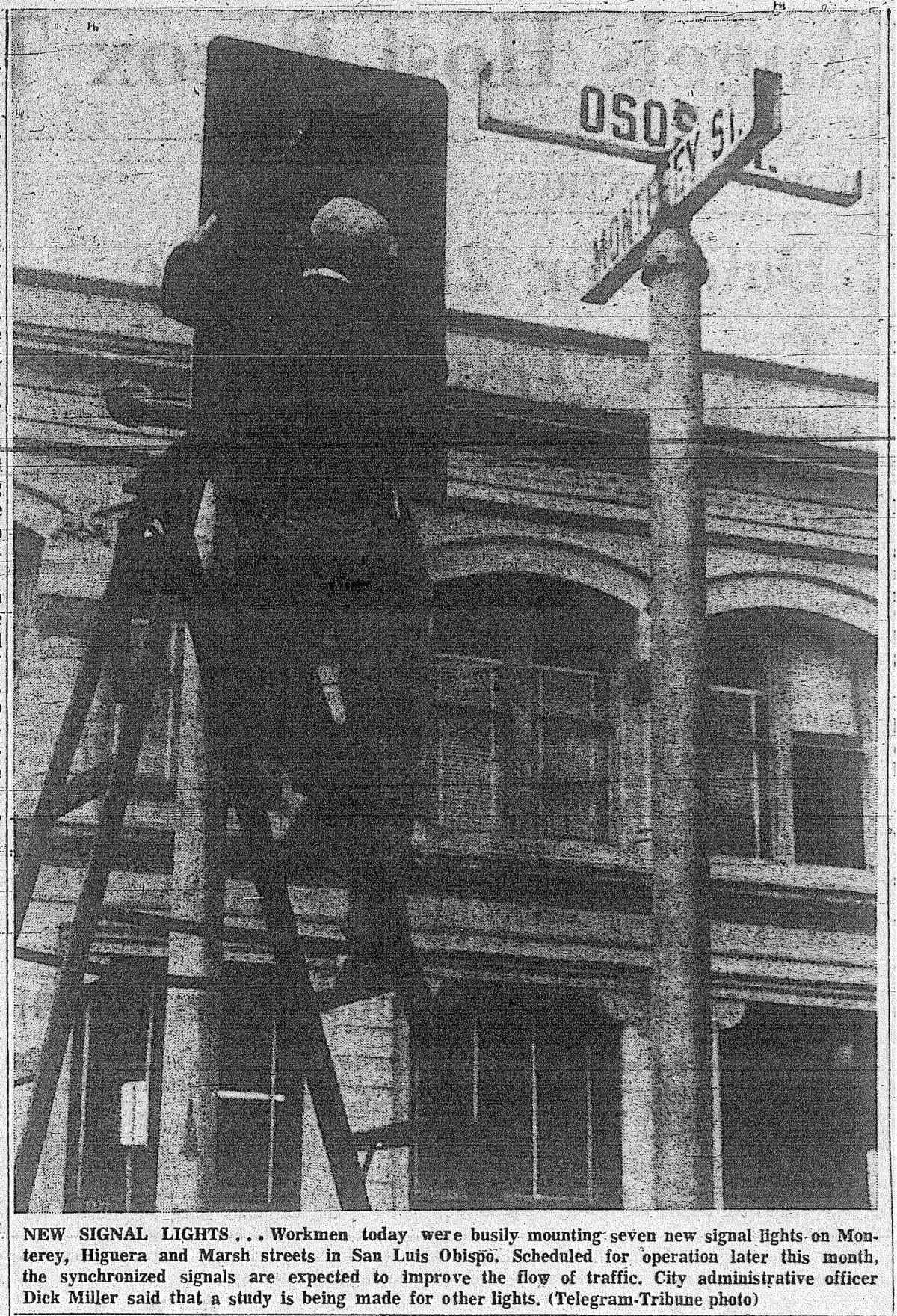 NEW SIGNAL LIGHTS…Workmen today were buisly mounting seven new signal lights on Monterey, Higuera and Marsh streets in San Luis Obispo. Scheduled for operation later this month, the synchronized signals are expected to improve the flow of traffic. City administrative officer Dick Miller said that a study is being made for other lights. Photo from the April 9, 1963 Telegram-Tribune.