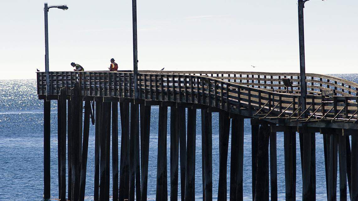 Workers look over the Cayucos Pier on Wednesday, Dec. 11, 2013, as they prepare for the first phase of repairs.