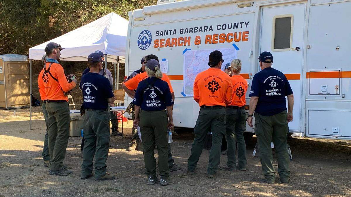Members of the Santa Barbara County Search & Rescue Team survey a map of the area being searched for Tim Sgrignoli, 29, of Ventura, who went missing while hiking on the Trespass Trail in Gaviota. His body was found off Highway 101 just north of the Gaviota Tunnel on Thursday, Sept. 8, 2022.