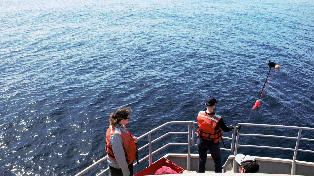 Kaitlin Palmer, left, and Anne Simonis, right, wait to retrieve their drifting buoy with a sound recorder attached on March 12, 2023. The sound recorder was deployed in the Pacific Ocean near the Morro Bay offshore wind energy area for about 30 minutes.