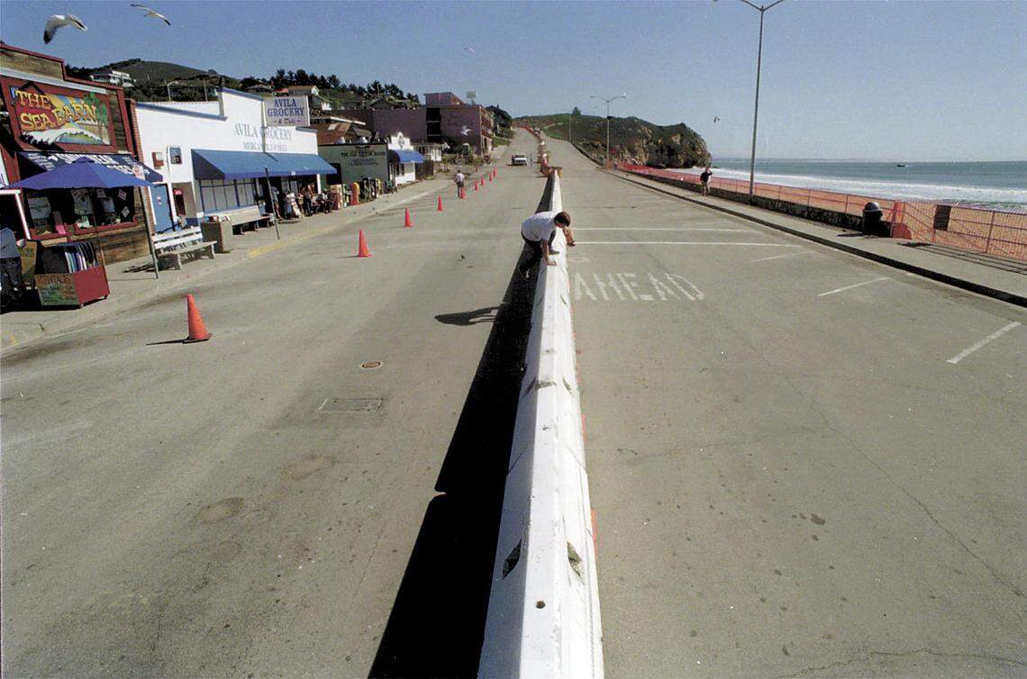 On his way to the beach in February 1999, Dale Berry hops over a newly placed barrier. The wall is part of Unocal’s project to clean up a 400,000-gallon toxic soup of petroleum products bubbling beneath the coastal town. Photo by Jayson Mellom