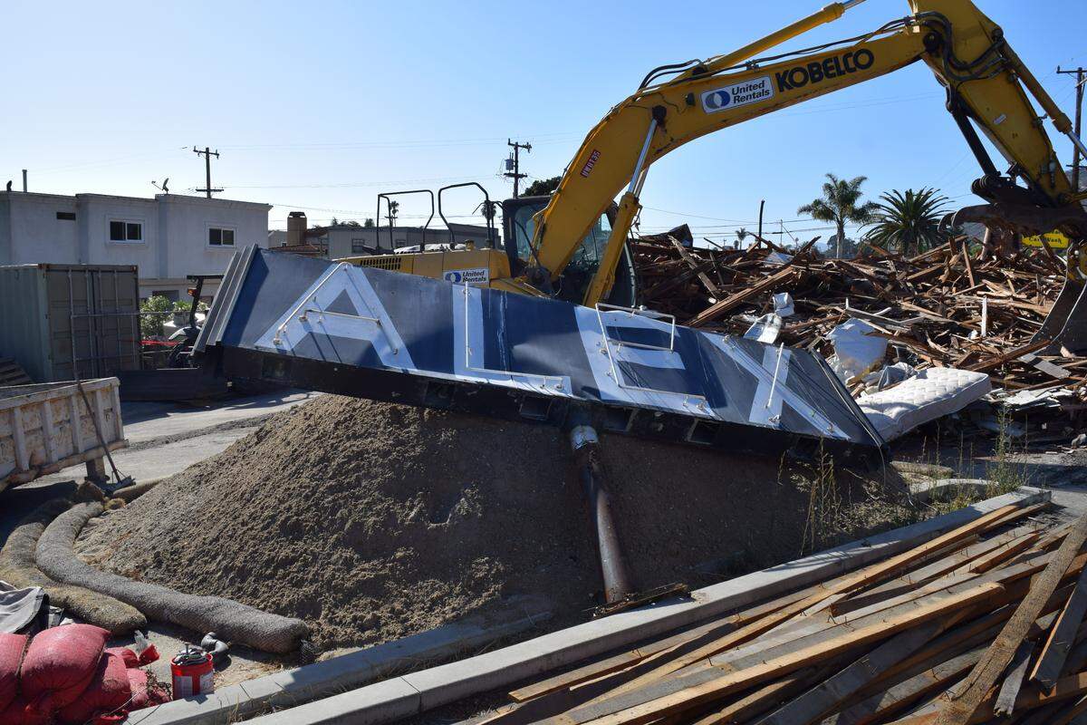 The historic Alex Bar-B-Q sign rests on a pile of rubble Tuesday after the historic building in Shell Beach was demolished, despite the contractor on the project only having a permit to remove the building’s tower. City representatives have halted work on the project.