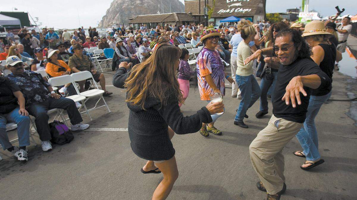 Brandy Relis, right, rocks out to the local music of The Shival Experience from Los Osos at the Morro Bay Harbor Festival in 2008.