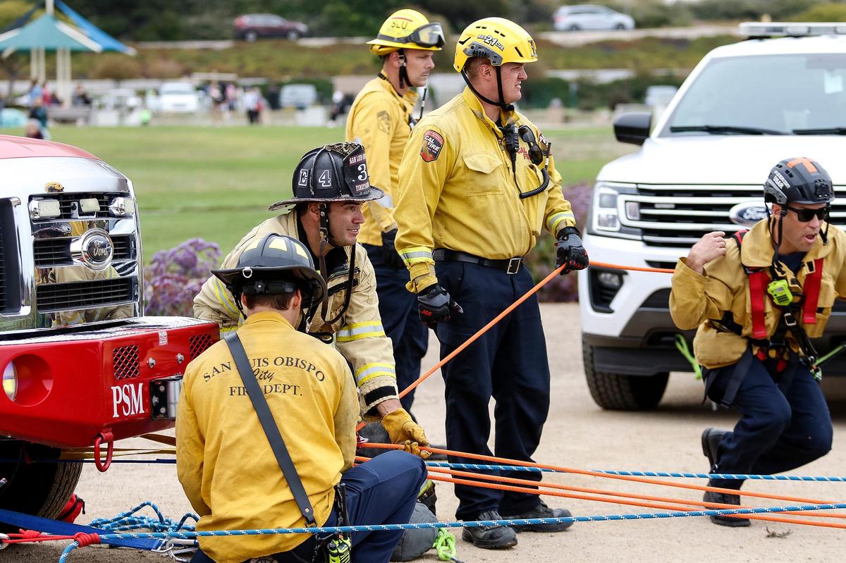 Firefighters cinch up the ropes leading to the crew members who repelled down the cliff to rescue Ryan McCormick and his dog Rosie, who went over a cliff chasing an animal at Dinosaur Caves Park in Shell Beach on June 29, 2023. They were OK after the rescue.