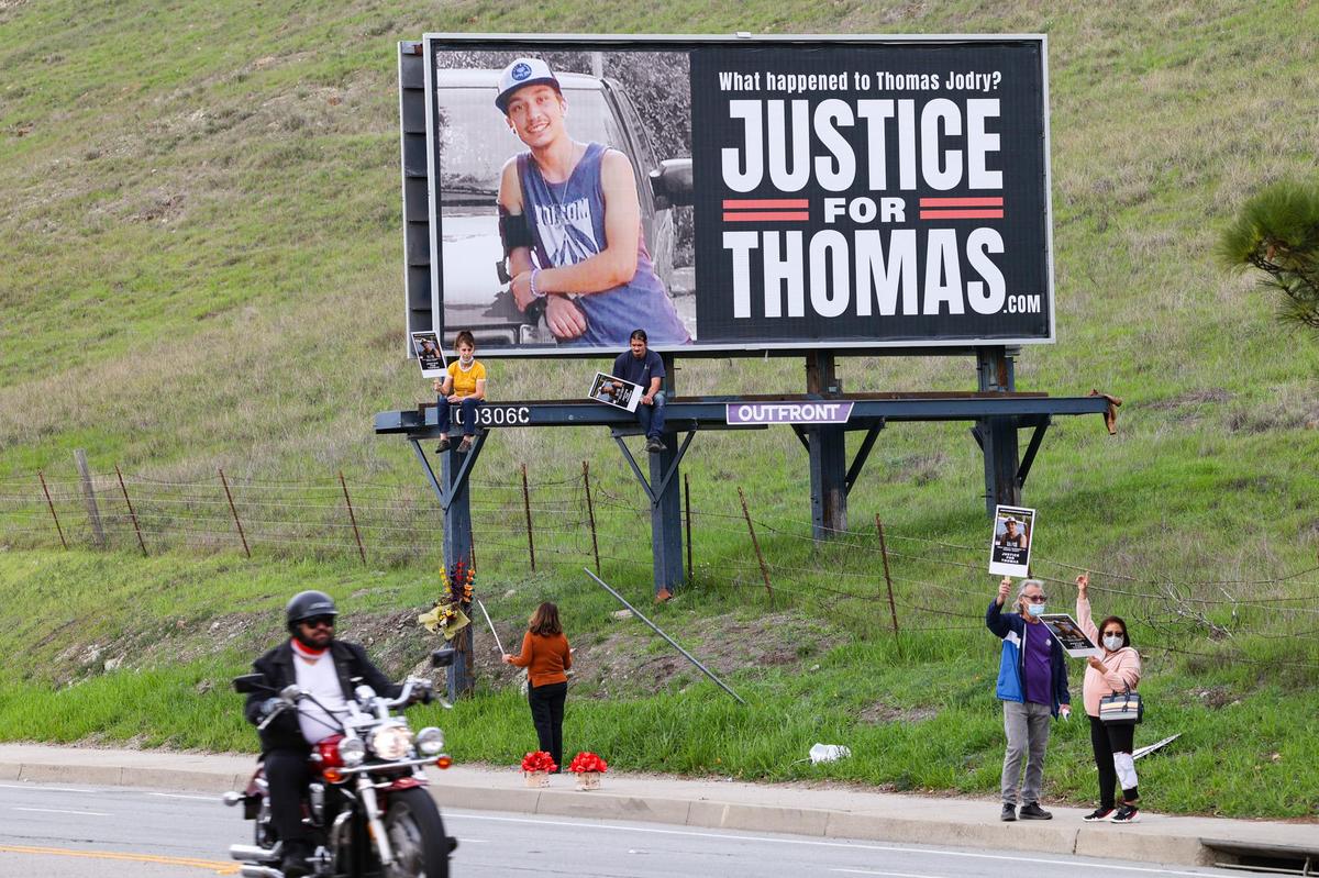 Bill and Mary Jane Jodry, right, attend a demonstration seeking answers in the death of their son, Thomas Jodry, who died in a 2019 fall from the Marsh Street parking garage. Supporters held up placards in front of a billboard on South Higuera Street in San Luis Obispo on Jan. 12, 2022. The billboard sign has since been moved to a new location on the side of Highway 101 at the base of the Cuesta Grade.