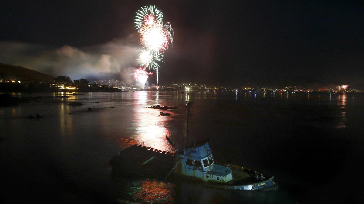 Fourth of July fireworks in Cayucos light up the sky over the grounded fishing boat Point Estero.