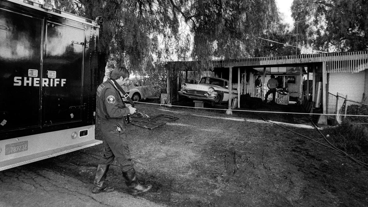 Evidence technician Gary Hoving walks toward the Nipomo home where a mother and three children were slain in January 1986. The investigators were there Jan. 6, 1986. Richard Allen Benson, a parolee with a history of child molestation convictions, was convicted of the murders of Laura Camargo and her children Sterling, Shawna and Stephanie.