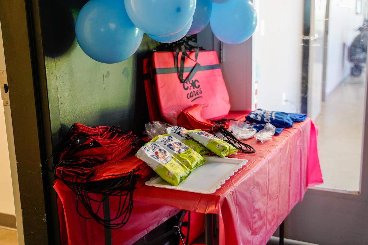 A table bearing Community Health Center-branded bags, snacks and sunscreen on Thursday, Aug. 7, 2025. CHC provides urgent and primary care to homeless clients of 40 Prado Homeless Services Center.