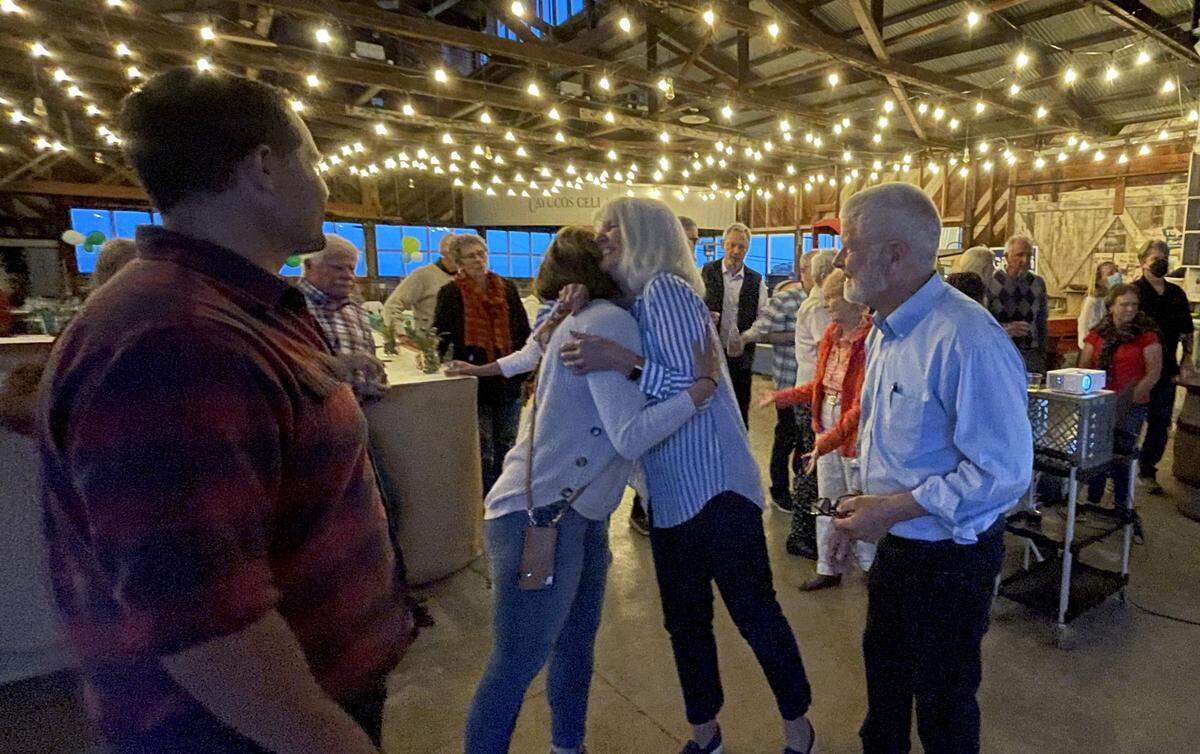 Supervisor Bruce Gibson watches as his wife Cherie hugs a supporter during his election night party at the Borradori Garage in Cayucos.