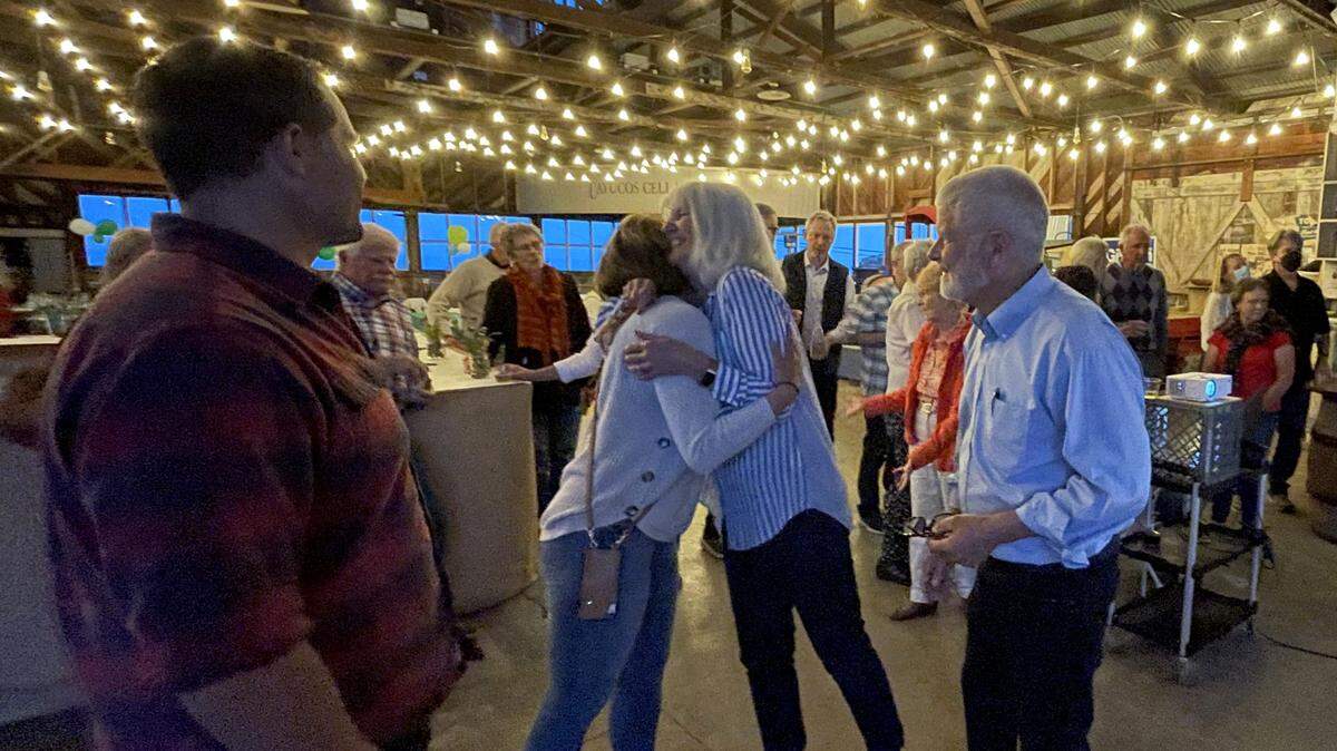 Supervisor Bruce Gibson watches as his wife Cherie hugs a supporter during his election night party at the Borradori Garage in Cayucos.