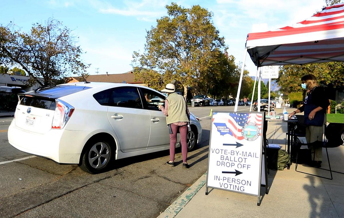 People in cars drop their absentee ballots off at the Ludwick Community Center gym in San Luis Obispo on Tuesday, Nov. 3, 2020. The Voter Service Center saw a steady procession of voters throughout the day.