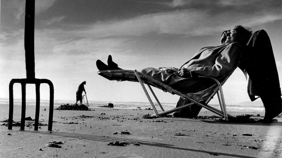 Mrs. Dora J. Ryan of Santa Maria, enjoys the comforts of home as friends clam at Pismo Beach in January 1965. “Some 30 years ago I used to come here with my boys, but we didn’t have to go out far for the clams,” said Mrs. Ryan. At 74 years of age, she will stay high and dry regardless of low tide.