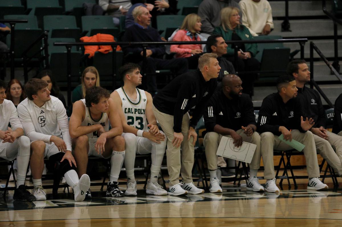 The Cal Poly Mustangs and coaches sit on the sideline watching the game. Cal Poly beat Seattle University 75-71 in a college basketball game at Mott Athletics Center on Nov. 14, 2024.