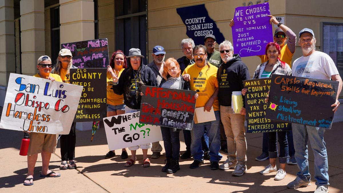 San Luis Obispo County Homeless Union members hold signs at an April 29, 2024 press conference at the Katcho Achadijan Government Center. The California Homeless Union reached an agreement with San Luis Obispo County to keep the Oklahoma Avenue Safe Parking site open until May 6.