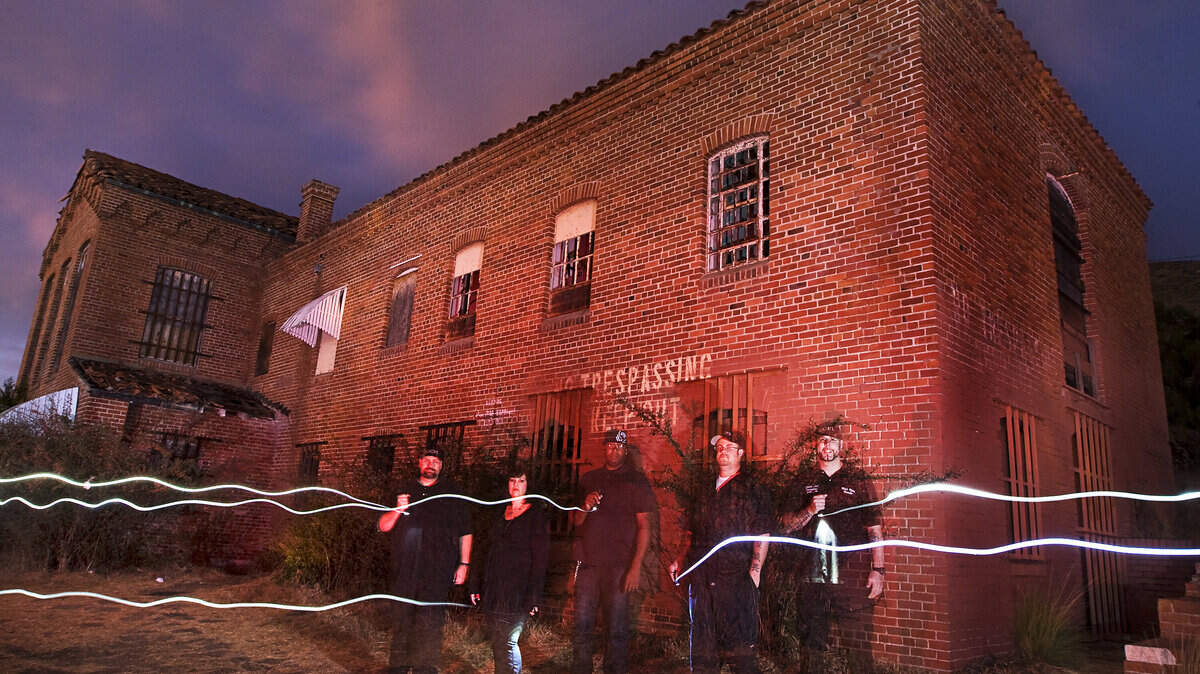 Central Coast Paranormal Investigators — from left, Rob Burr, Ray Anne Brewen John Harrison, Micah Watkins and Mitch Flores — pose outside the abandoned Sunny Acres building in San Luis Obispo.