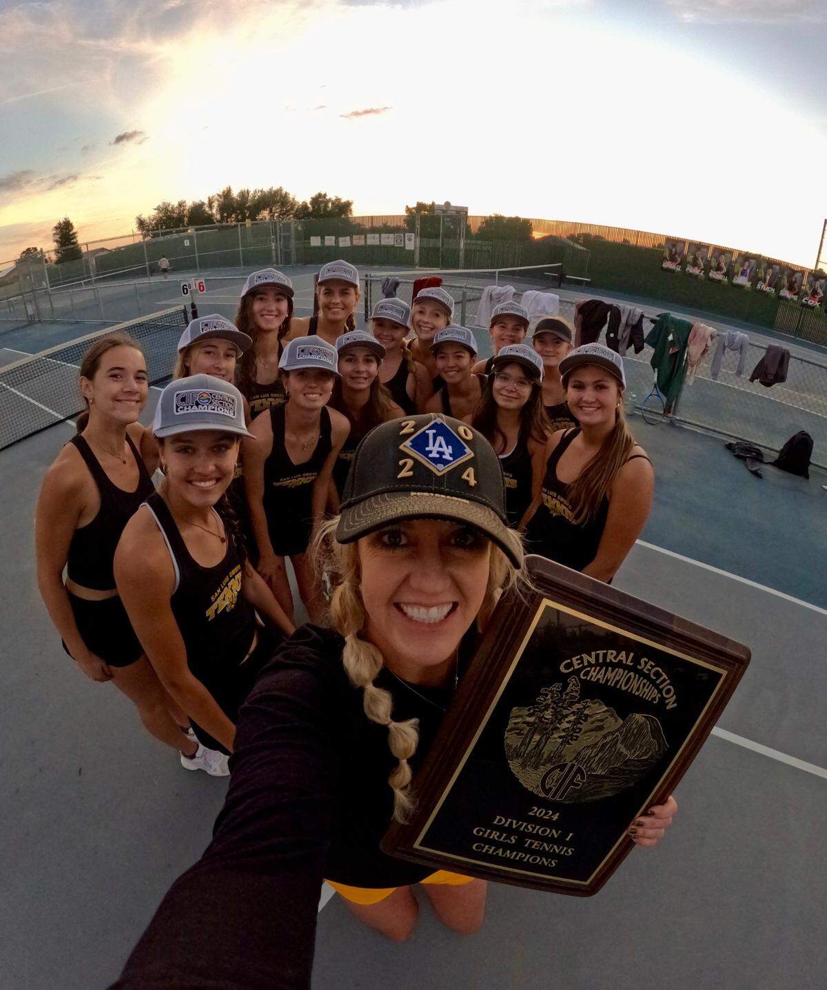 San Luis Obispo girls tennis won the CIF-Central Section Division 1 title with a 5-4 victory over Liberty earlier this month. Coach Michelle Heidbrink (center holding plaque) celebrates with the team.