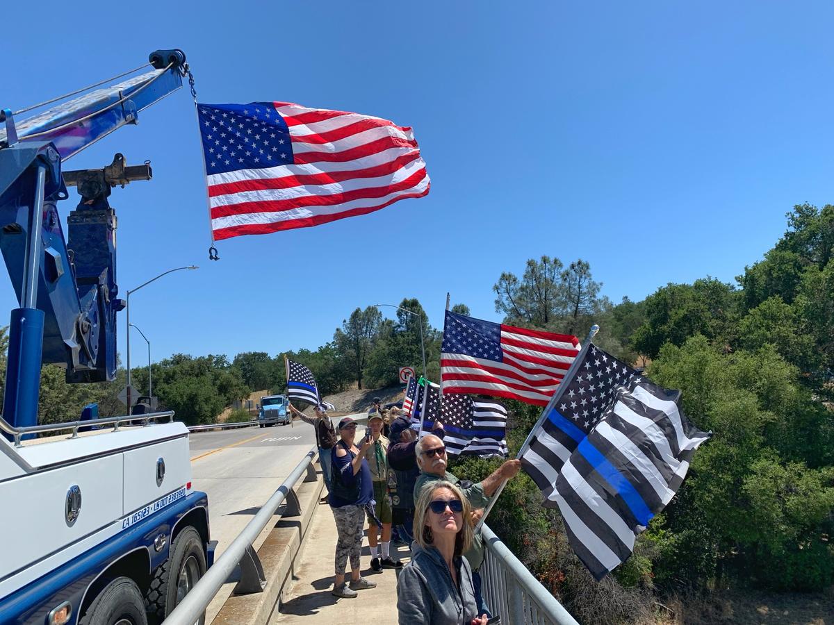 People gathered on a Highway 101 overpass in Atascadero to watch the funeral procession of Det. Luca Benedetti, who was killed in San Luis Obispo on May 10.